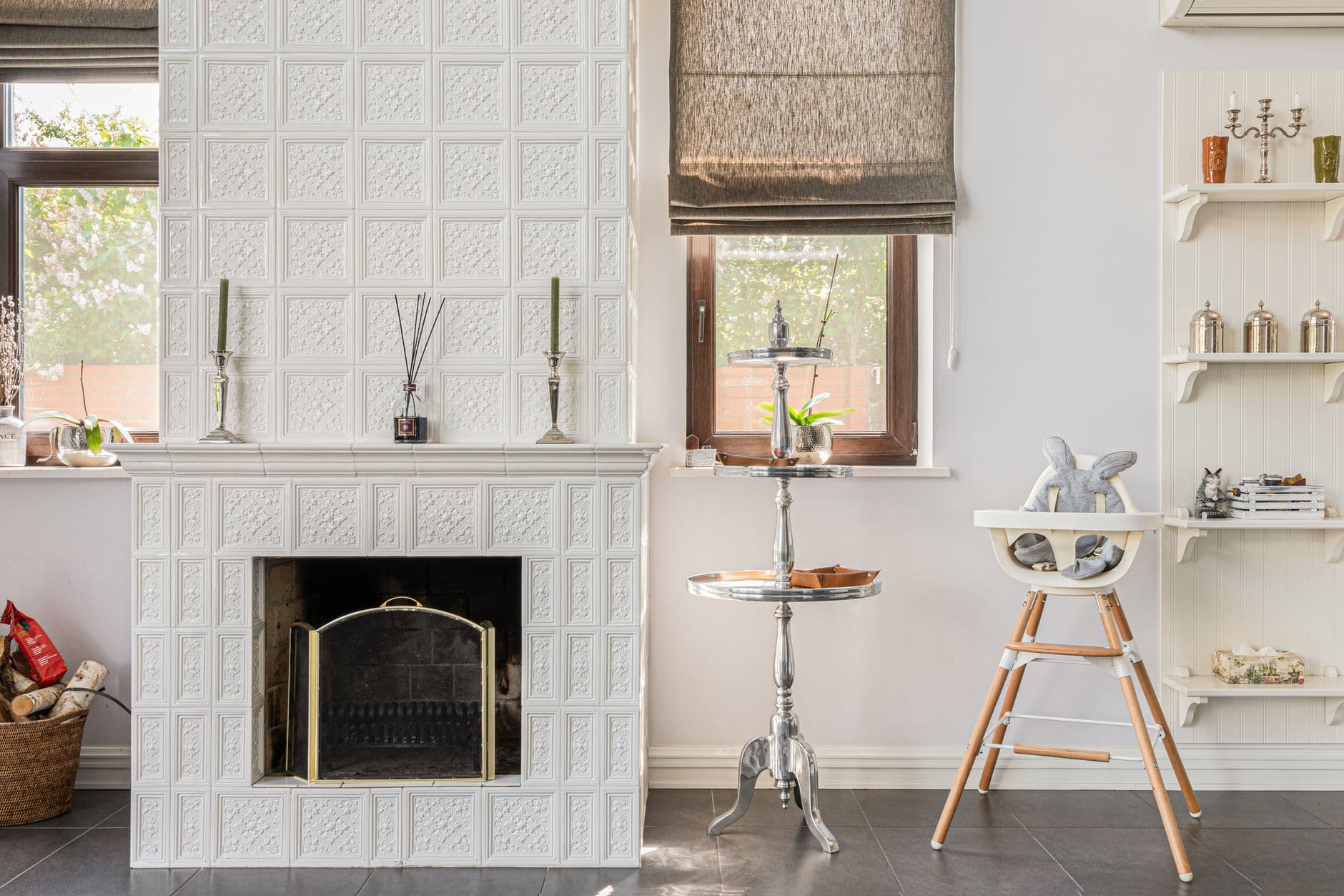 A chic interior featuring a white ornate fireplace, stylish furniture, and modern decor elements.